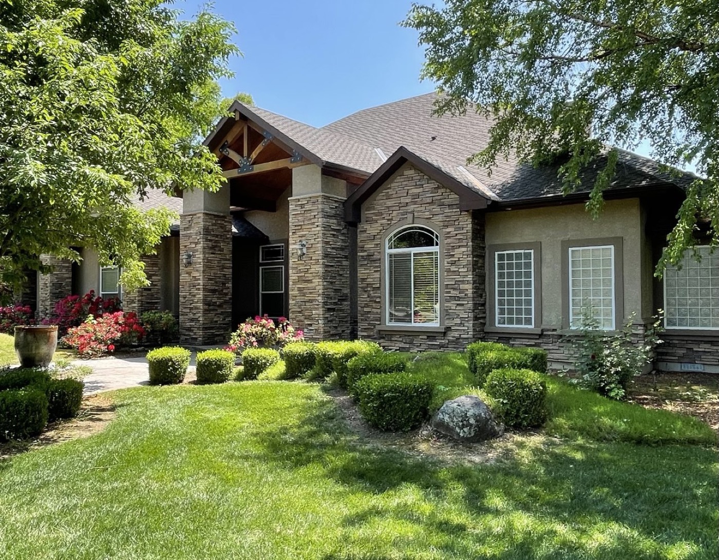 Paver walkway with tulip flower beds and blossoming tree