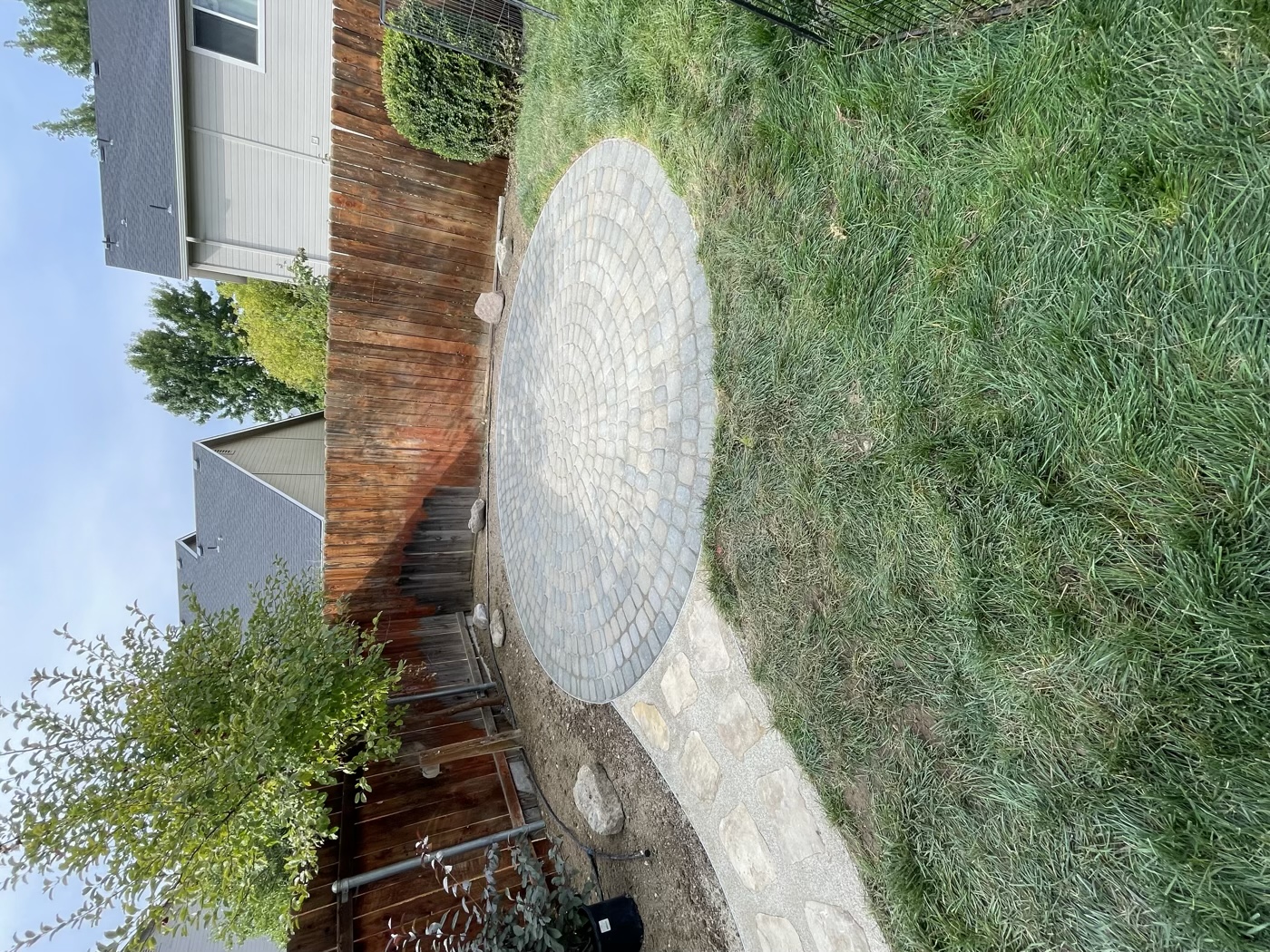 Circular stone paver patio in backyard
