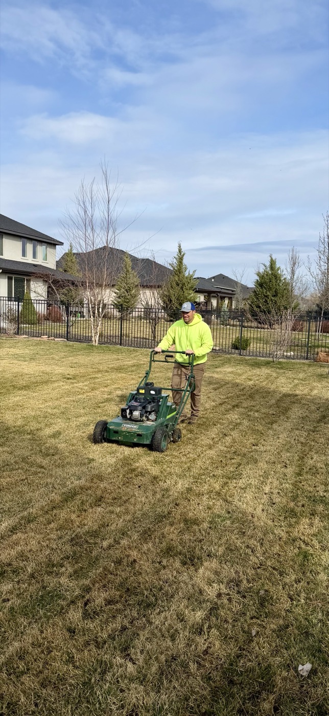 Crew member mowing lawn during seasonal maintenance